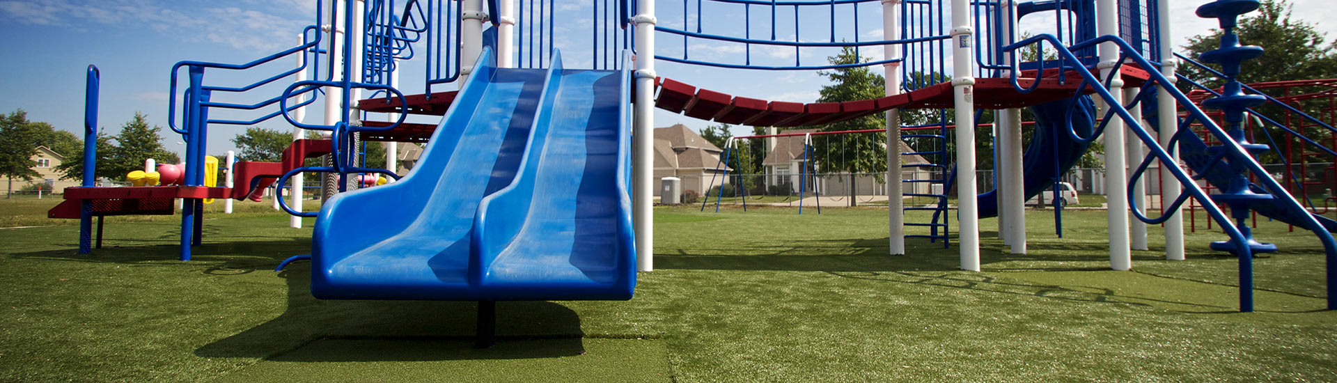 SYNLawn Tramplezone featured underneath double blue slide at Kansas playground